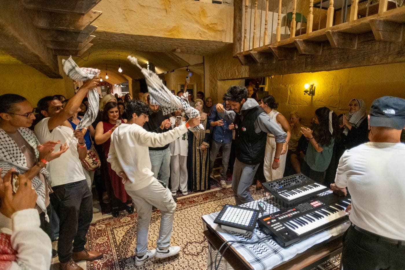 Guests dancing at a House celebration beside a keyboard player.