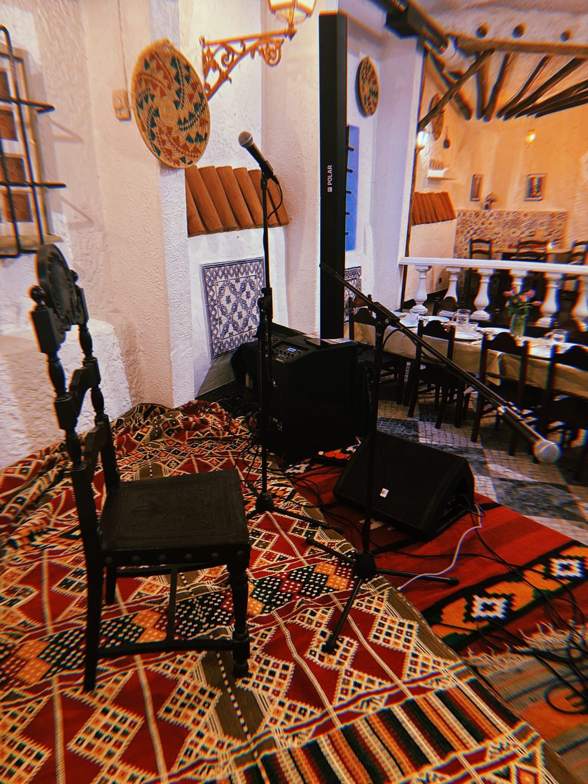 A stage set with instruments and woven rugs before a performance.