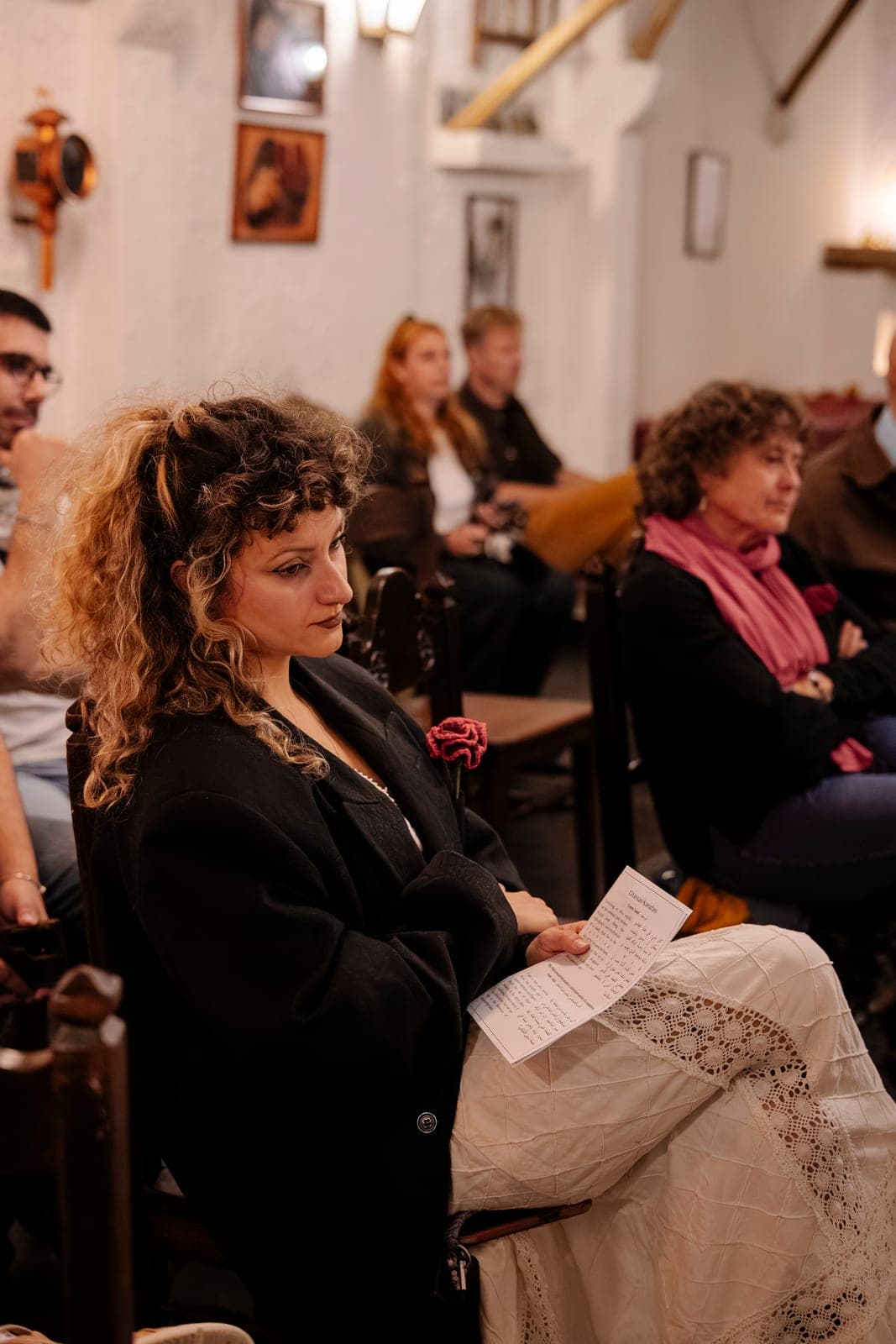 A guest listening intently during a House gathering.